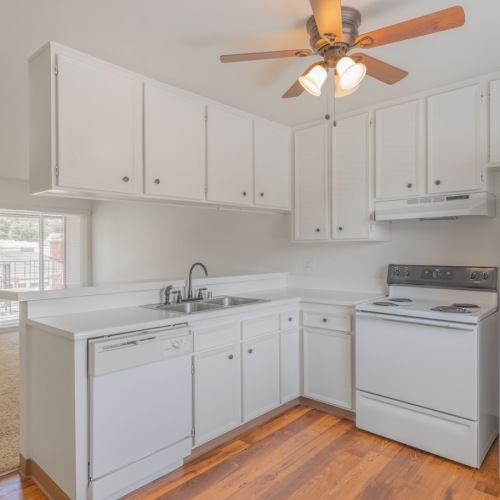 Spacious kitchens with thoughtful details kitchen with wood floors white cabinets a fridge and stovetop