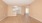 an empty room with a window and kitchen access