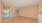 an empty living room with a front door and a window