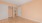 an empty room with a door and closet access