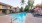 a pool in a courtyard with umbrellas and loungers