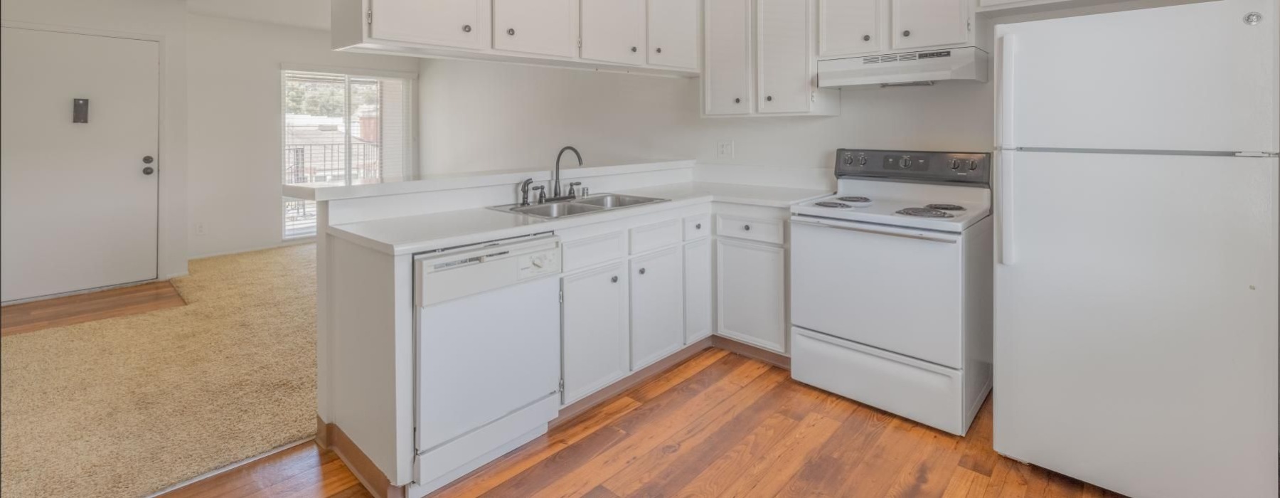 a kitchen with white cabinets and a ceiling fan