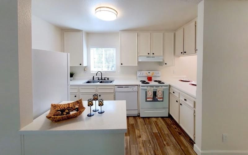 a kitchen with white cabinets and a small window